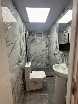 A bathroom with a toilet, sink, and shower. - Klas Otel (Karasu)