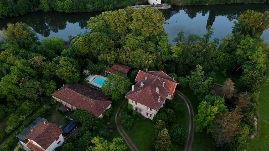 Un vaste domaine comprenant plusieurs bâtiments, une piscine et un lac.