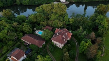 Un vaste domaine comprenant plusieurs bâtiments, une piscine et un lac.
