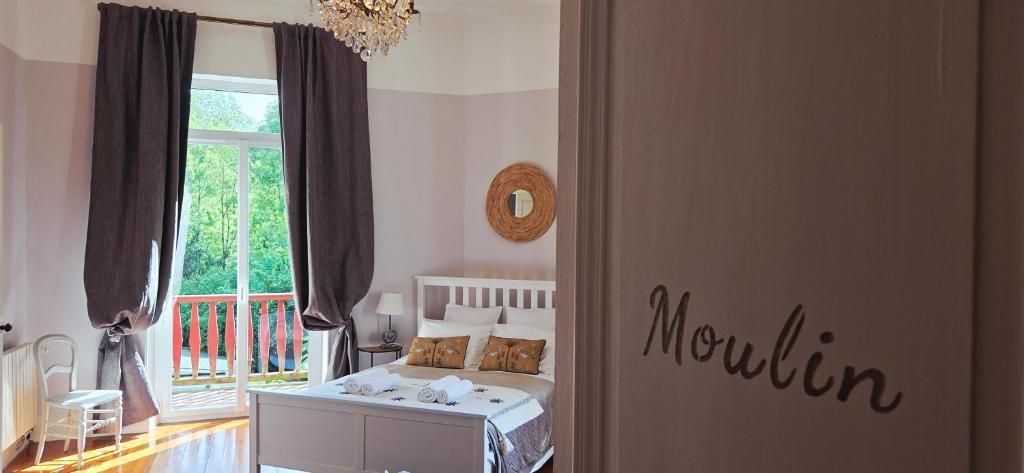 Une chambre à coucher avec un lit, une fenêtre avec des rideaux, une table de chevet et un mur sur lequel est écrit le mot « Moulin ».
