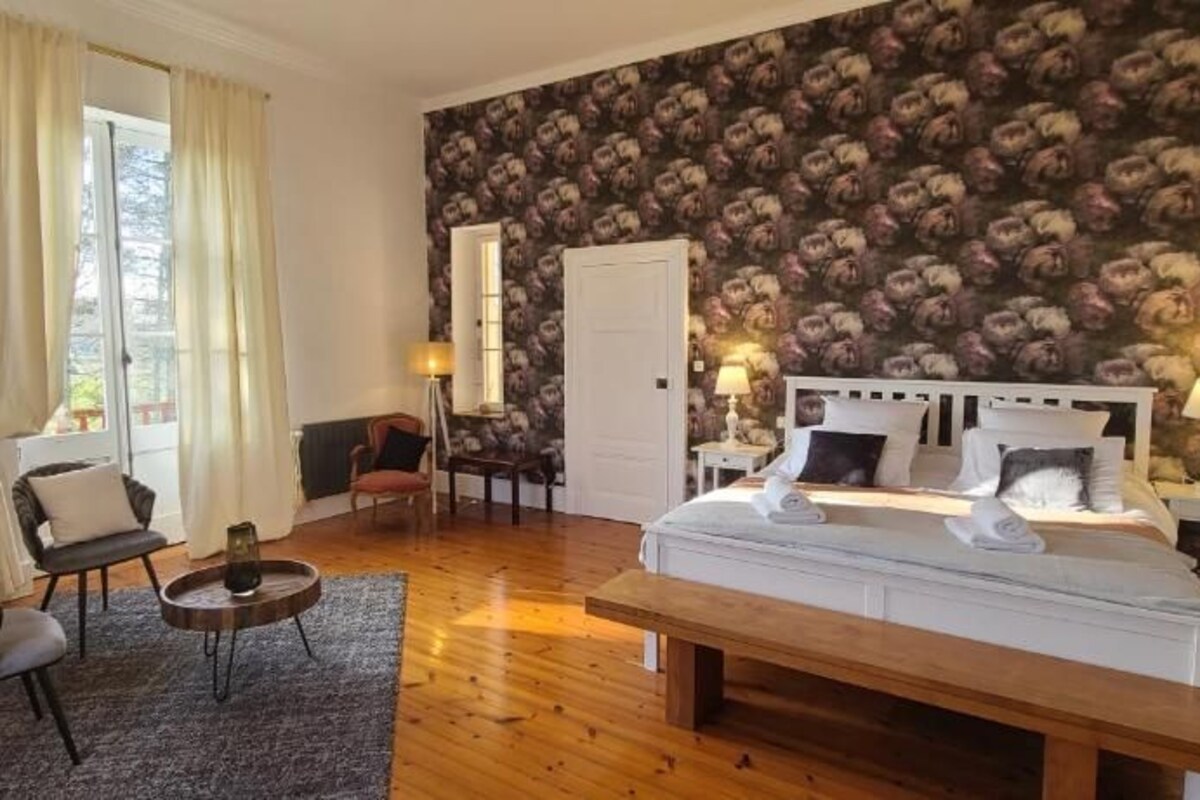 Un dormitorio con una cama grande, un escritorio, una silla y un armario.
