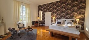 Un dormitorio con una cama grande, un escritorio, una silla y un armario.