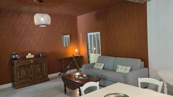 Un salon avec un canapé, une table et un meuble.