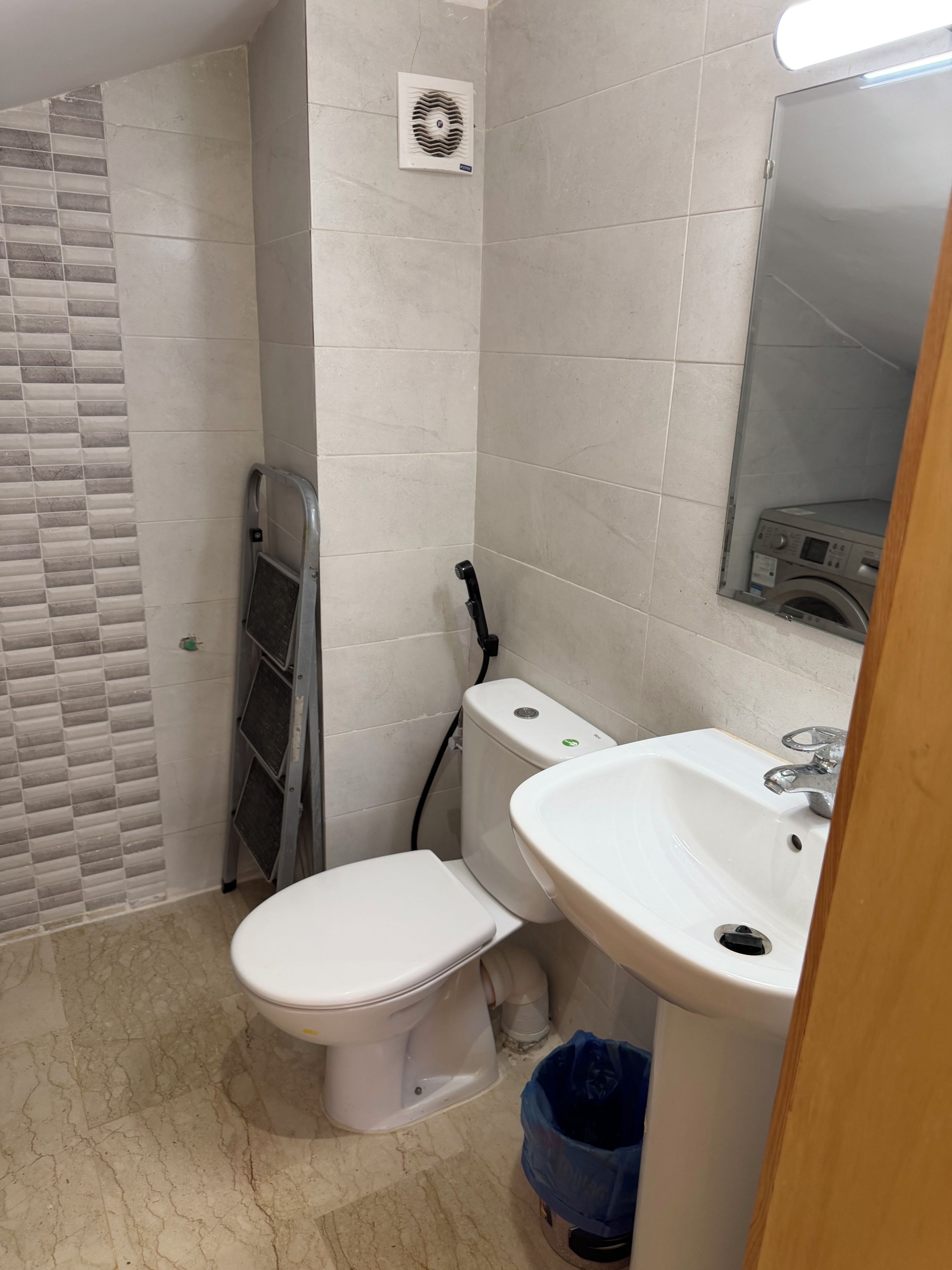 Une petite salle de bain avec des toilettes, un lavabo et un miroir.