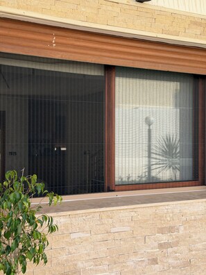 A modern building facade with large windows and a brick wall.