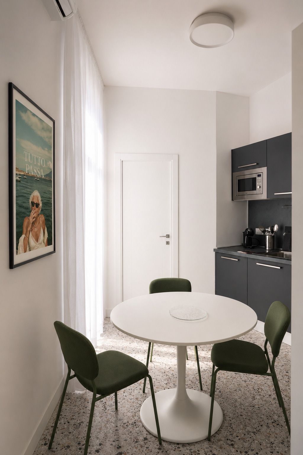 Una cocina moderna con una mesa redonda y sillas, un microondas y una cafetera.