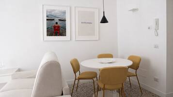 Un comedor moderno con una mesa redonda, cuatro sillas y dos cuadros en la pared.