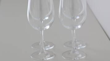 Dos copas de vino transparentes sobre una superficie blanca.