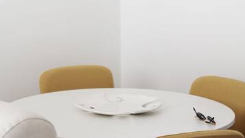 Una mesa blanca con un plato blanco y un par de gafas de sol.