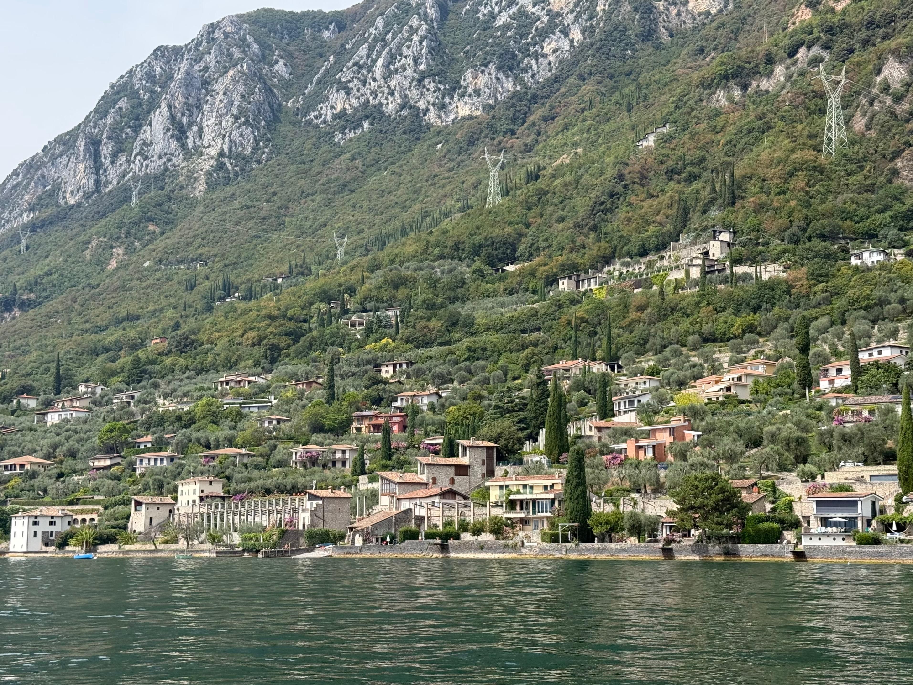 Une ville côtière avec des bâtiments le long du front de mer, une chaîne de montagnes en arrière-plan et une étendue d'eau au premier plan.