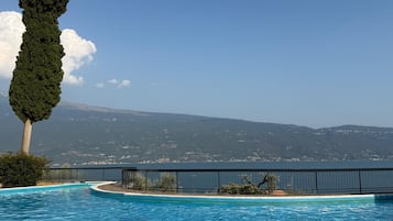Une piscine offrant une vue sur une chaîne de montagnes et un plan d’eau.