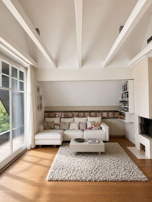 A modern living room with a white sofa, a coffee table, and a bookshelf. - Romantic Villa on Lake Millstatt (Seeboden)