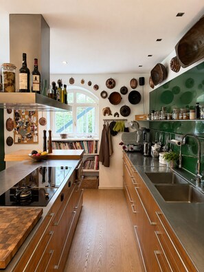 Une cuisine moderne dotée d’un îlot central, de meubles en bois et d’une variété d’ustensiles de cuisine et d’accessoires.