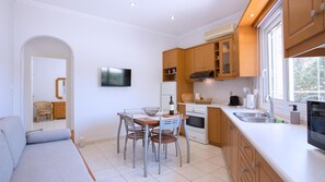 A modern kitchen with wooden cabinets, a dining table with chairs, and a built-in oven.