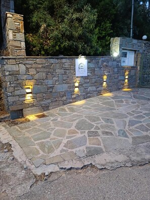 A stone wall with embedded lighting fixtures and a sign.