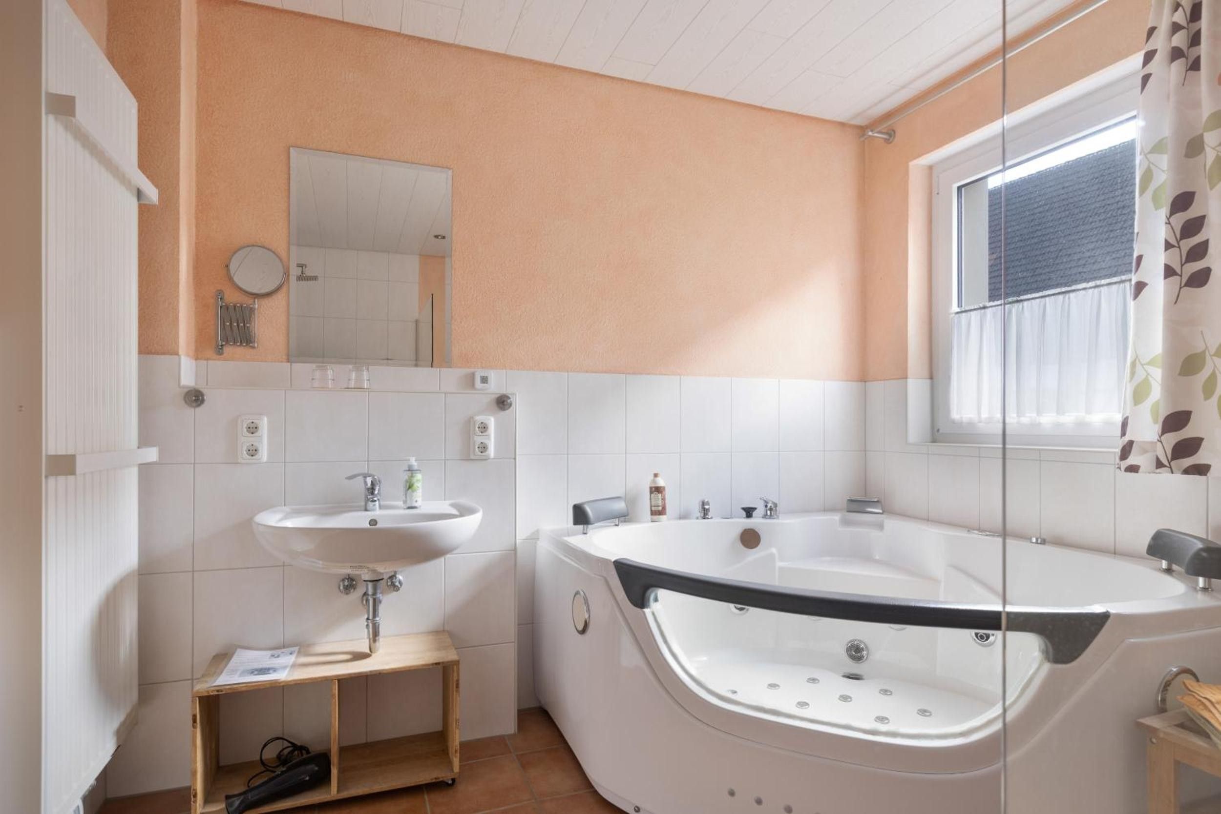 Ein modernes Badezimmer mit einer Badewanne, einem Waschbecken und einem Spiegel.