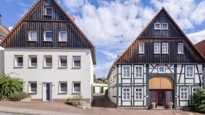 Twee traditionele vakwerkhuizen met veel ramen en een heldere lucht.