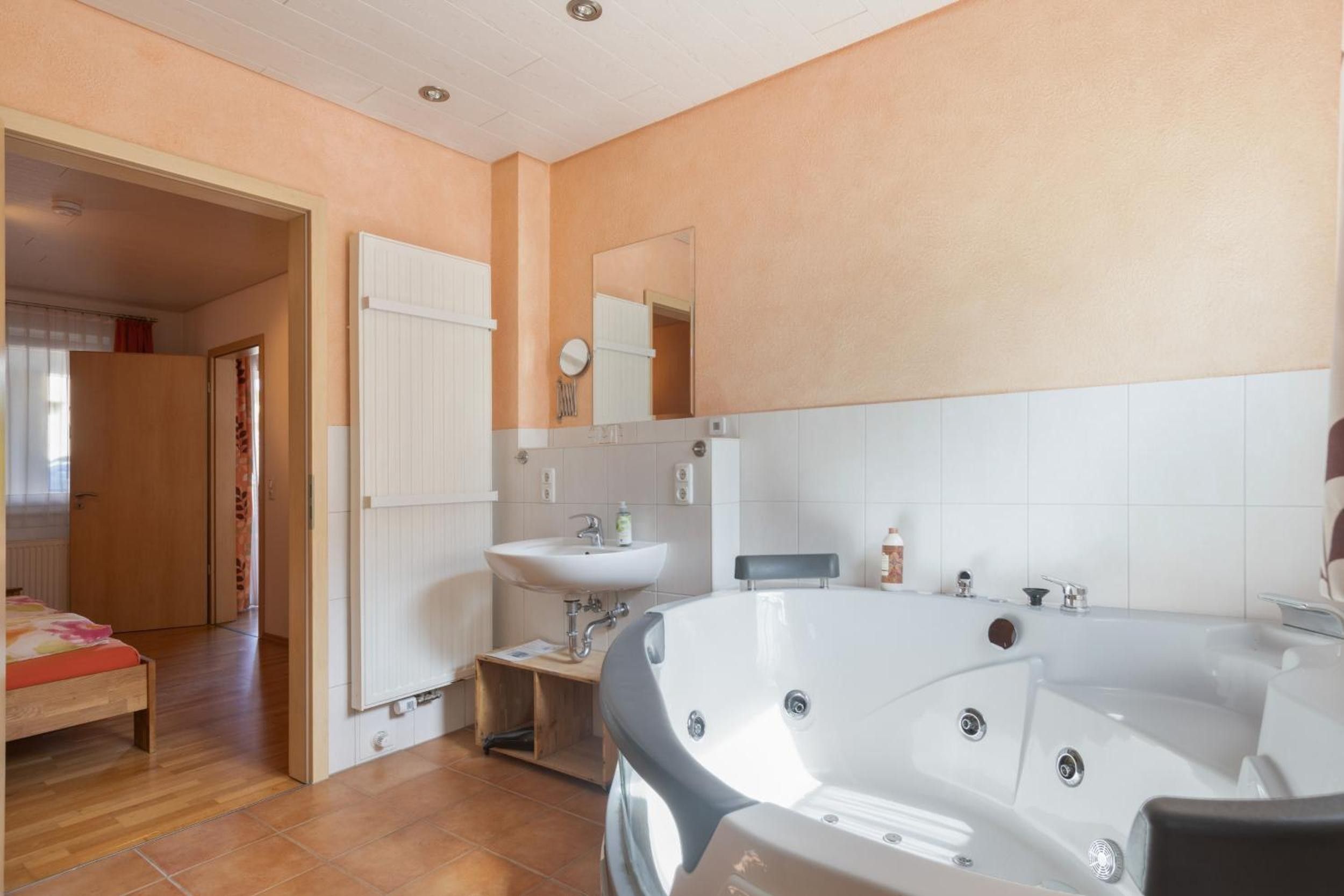 Ein Badezimmer mit einer Badewanne, einem Waschbecken und einem Spiegel.