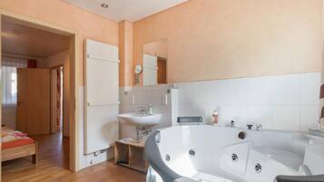 Ein Badezimmer mit einer Badewanne, einem Waschbecken und einem Spiegel.