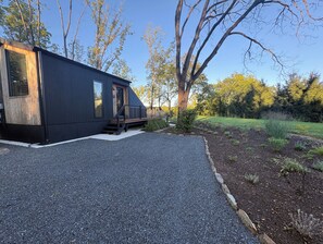 A modern building with a gravel driveway and a wooden deck.