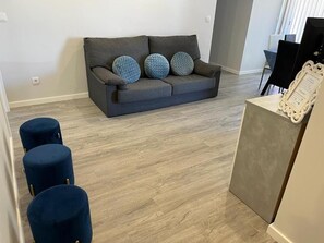 A living room with a grey sofa, three blue cushions, and a white decorative frame on a table. - Ocean Paradise Til (Funchal)