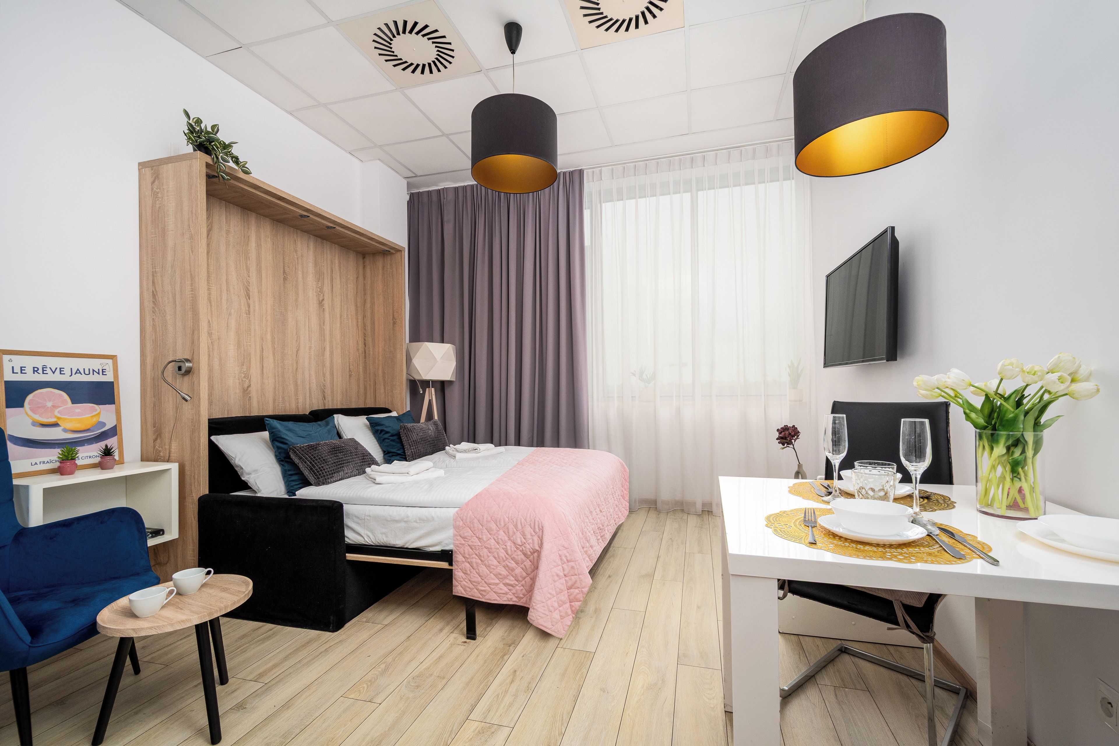 Une chambre d’hôtel moderne équipée d’un lit, d’une table de chevet, d’une chaise et d’un coin repas avec une table et des chaises.