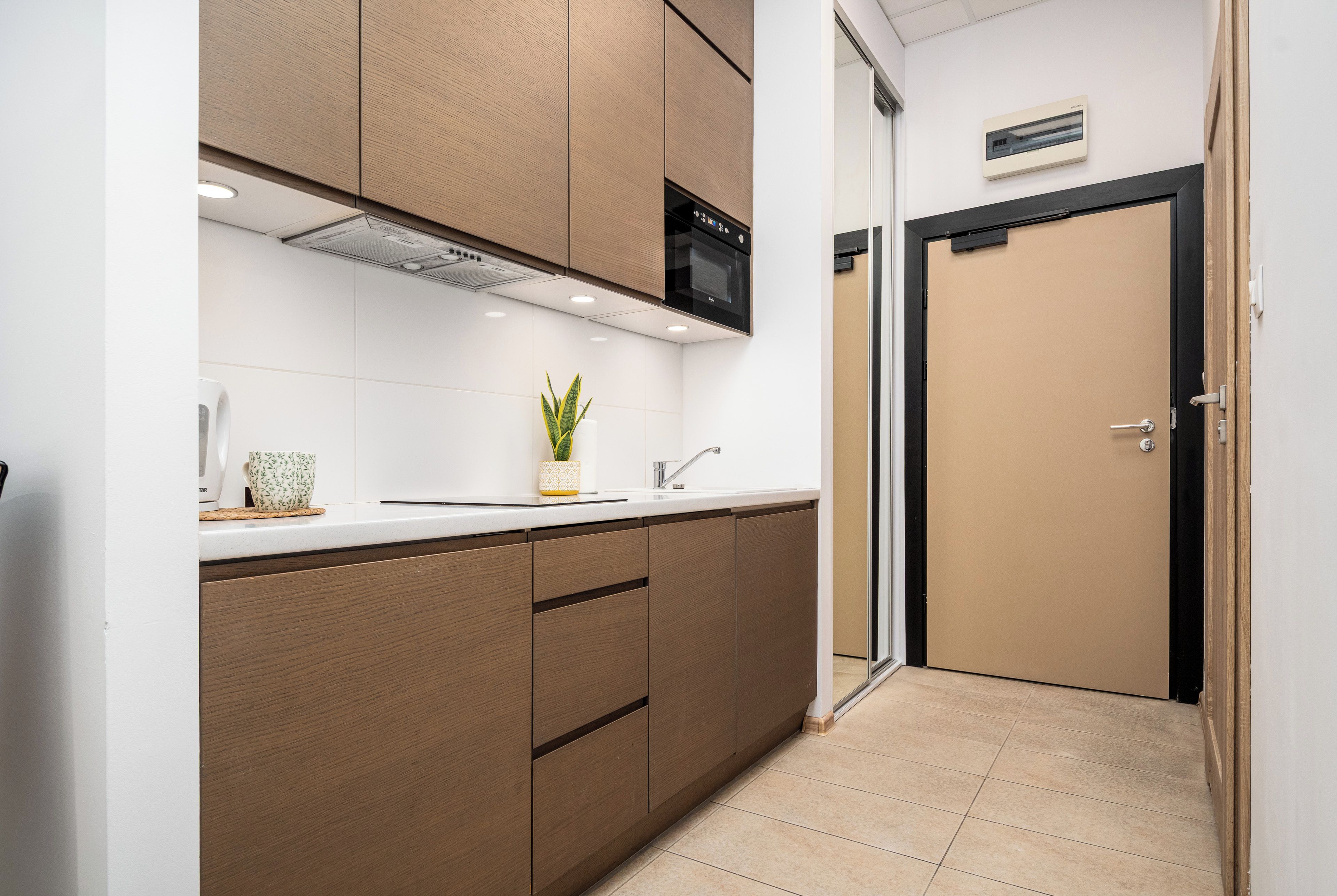 Une cuisine moderne avec des meubles en bois, un four encastré et un évier.