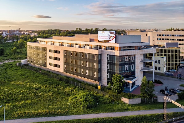Een modern gebouw met meerdere verdiepingen, grote ramen en een plat dak.