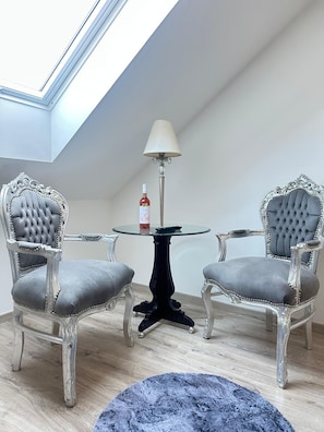 A room with two ornate chairs, a small round table, a floor lamp, and a blue rug. - Exclusive 1 bedroom suite at Vác Danube Bend (Budapest)