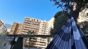 Een hangmat met uitzicht op wolkenkrabbers en een boom.