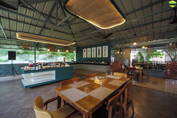 A restaurant with a high ceiling, a bar area, and a seating area with tables and chairs.