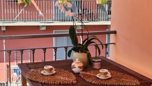 A balcony with a table, potted plants, and a railing. - Apartment 'Eddy Home' with Wi-Fi (Bellano)