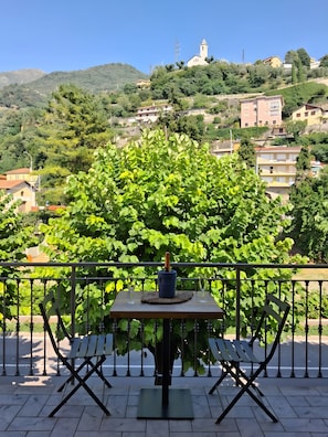 Eine Terrasse mit einem Tisch, zwei Stühlen und einer Champagnerflasche.