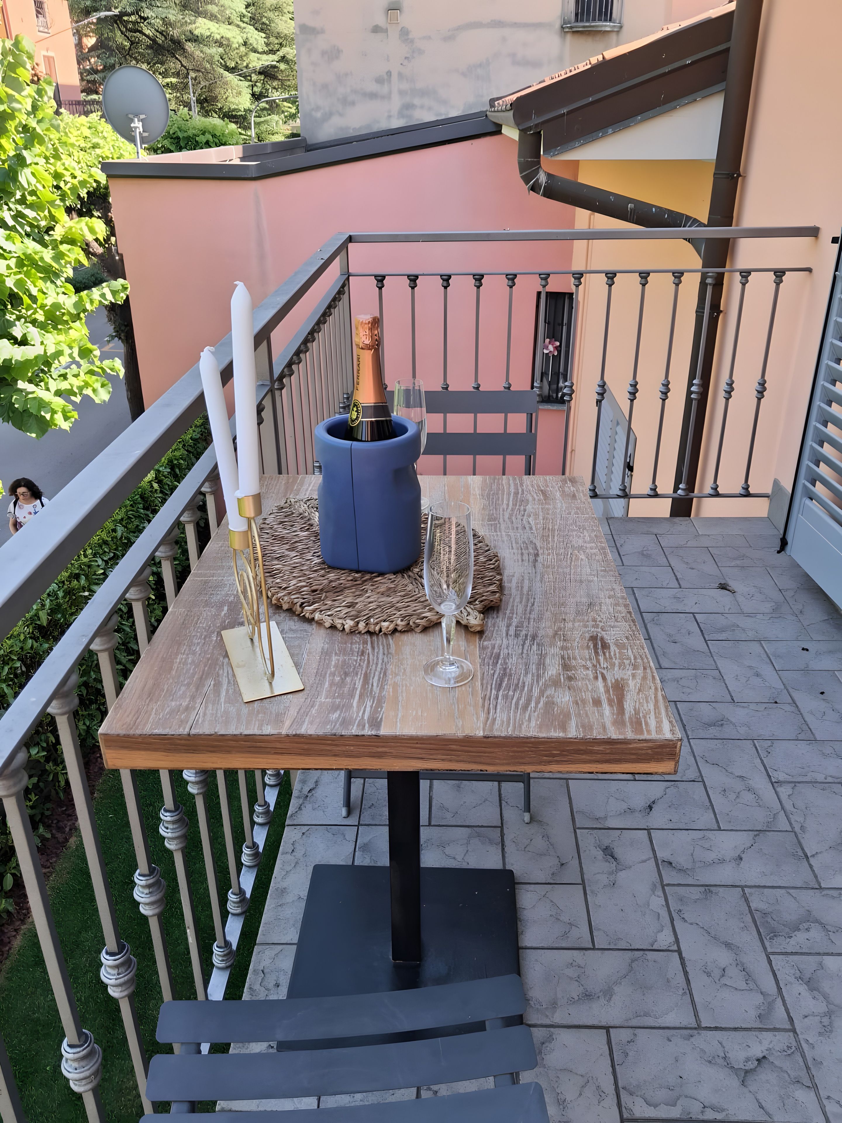 Un balcon avec une table dressée pour deux personnes, agrémentée d’une bouteille de champagne et de deux verres.