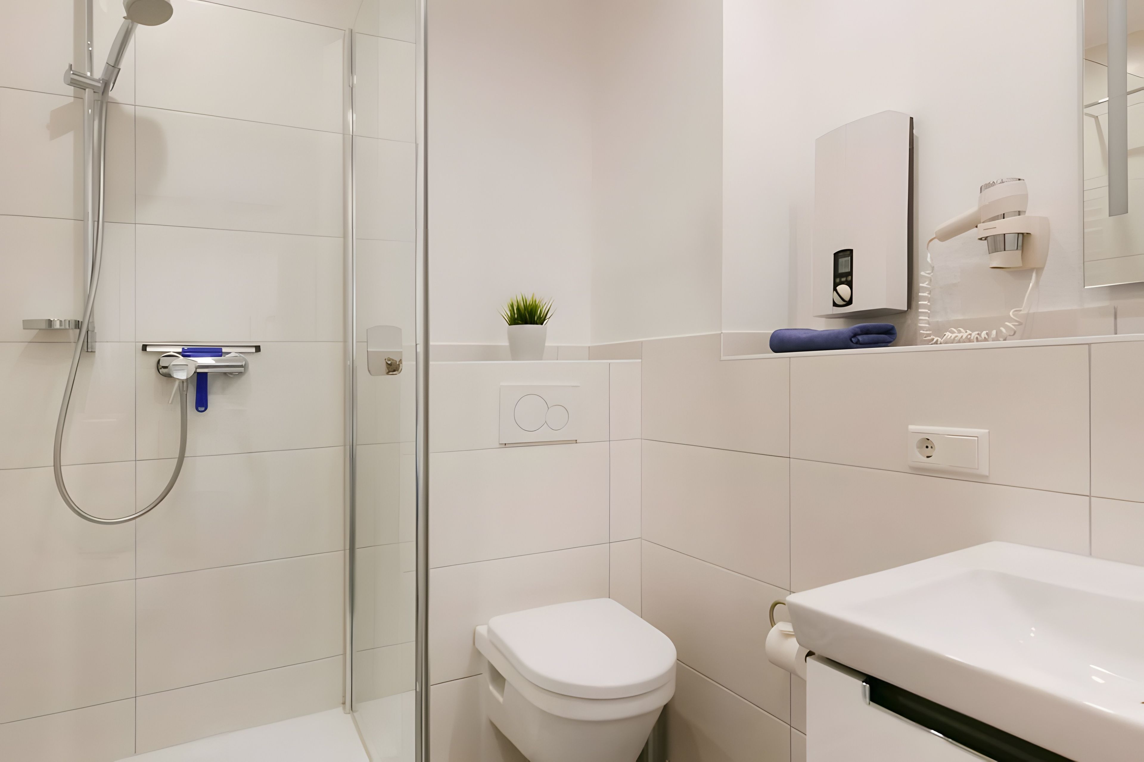 Une salle de bain moderne avec une douche à parois de verre, des toilettes et un lavabo.