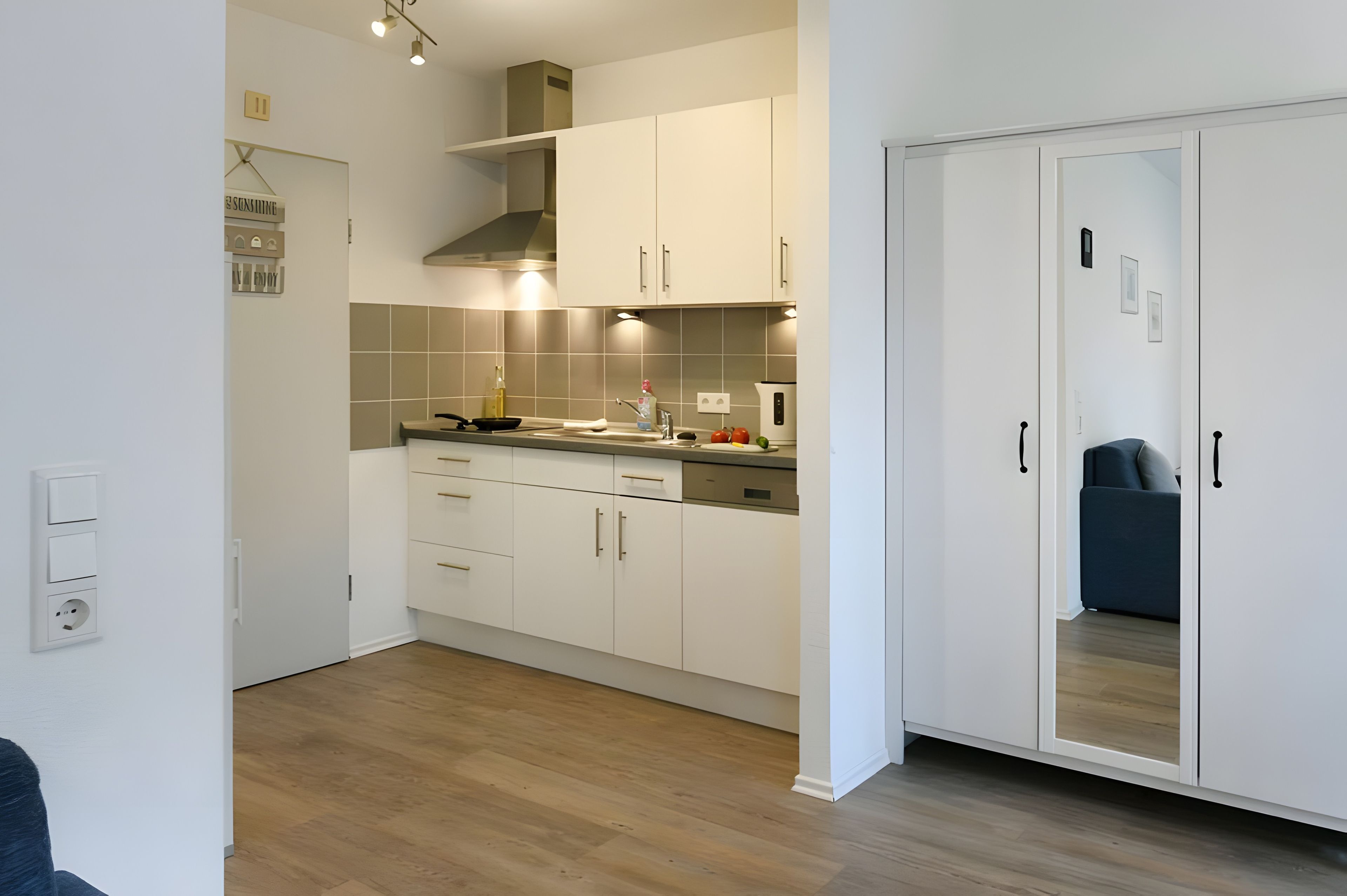 Eine moderne Küche mit weißen Schränken, einer Holz Arbeitsplatte und einem eingebauten Backofen.