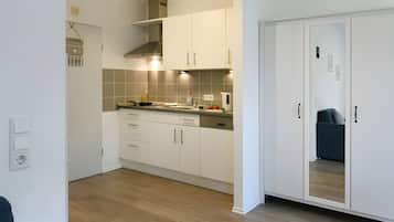 Eine moderne Küche mit weißen Schränken, einer Holz Arbeitsplatte und einem eingebauten Backofen.