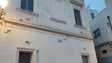 A two-story building with a flat facade, two ground-level windows, and a door.