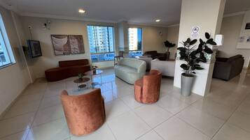 A spacious living area with a sofa, armchairs, and a coffee table.