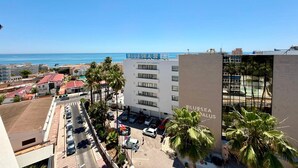 A hotel with a view of the sea, a parking lot, and a street with cars. - Vrbo Property (Torremolinos)