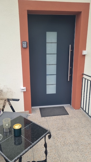 A modern door with a keypad lock, a small window, and a metal handle. - At home in Oppenheim (Oppenheim)