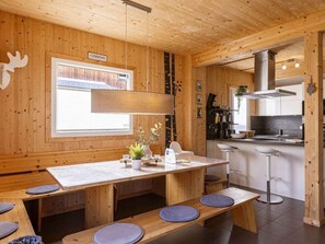 A wooden interior with a dining area, kitchen, and a sign on the wall. - One-bedroom Cabin (Sankt Georgen am Kreischberg)