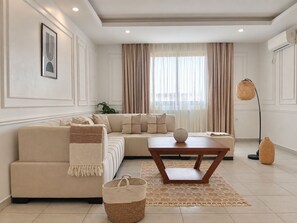 Uma sala de estar moderna com sofá, mesa de centro, abajur e cesta de palha.