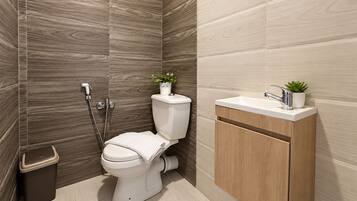 Un baño moderno con inodoro, bidé y lavamanos.