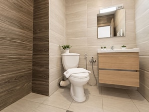 Un baño moderno con inodoro, lavamanos y espejo.