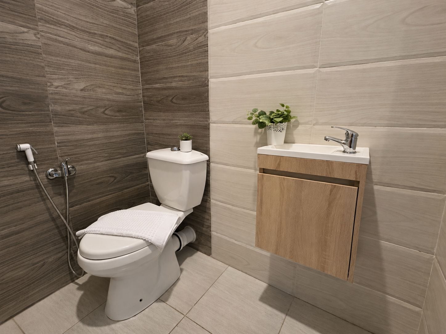 A modern bathroom with a toilet, shower, and sink.