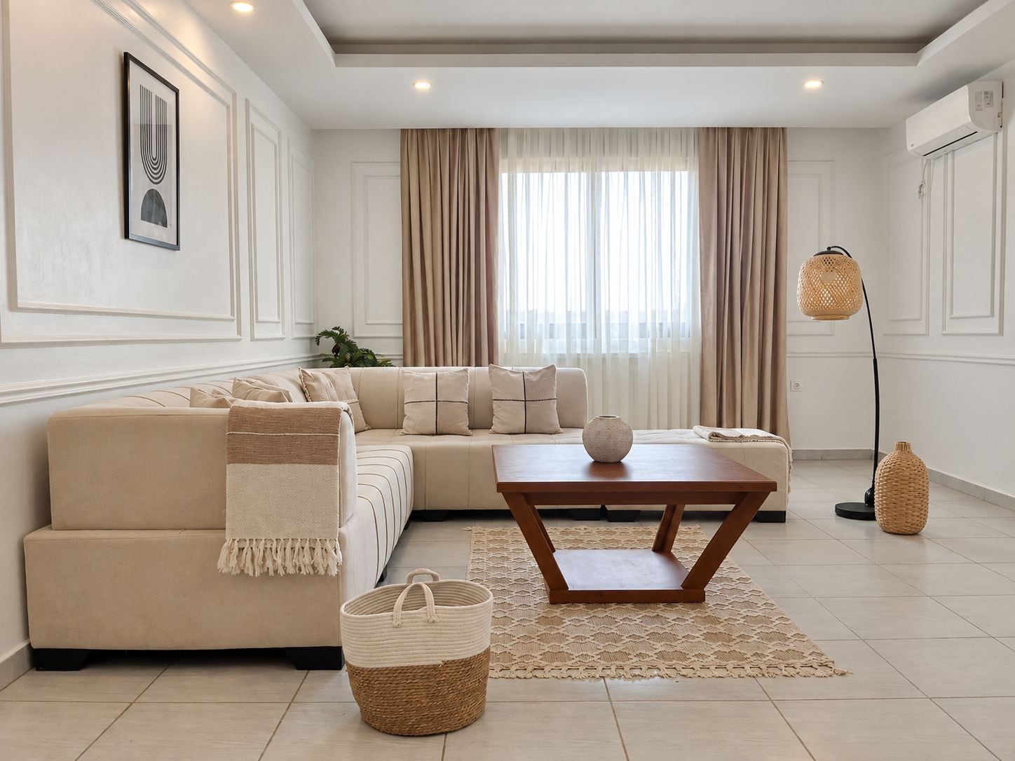Una sala moderna con un sofá modular, una mesa de centro de madera, una cesta tejida y una lámpara de pie.
