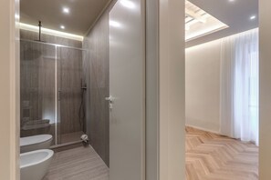 Une salle de bain moderne avec une douche à parois de verre, des toilettes et un bidet.