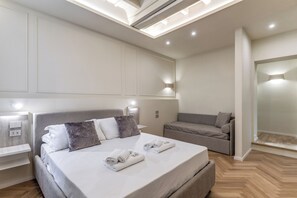 Une chambre moderne avec un grand lit, des tables de chevet, un canapé et un miroir.