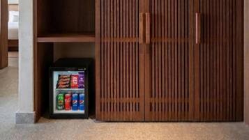 Un armario de madera con un estante incorporado y un refrigerador pequeño.